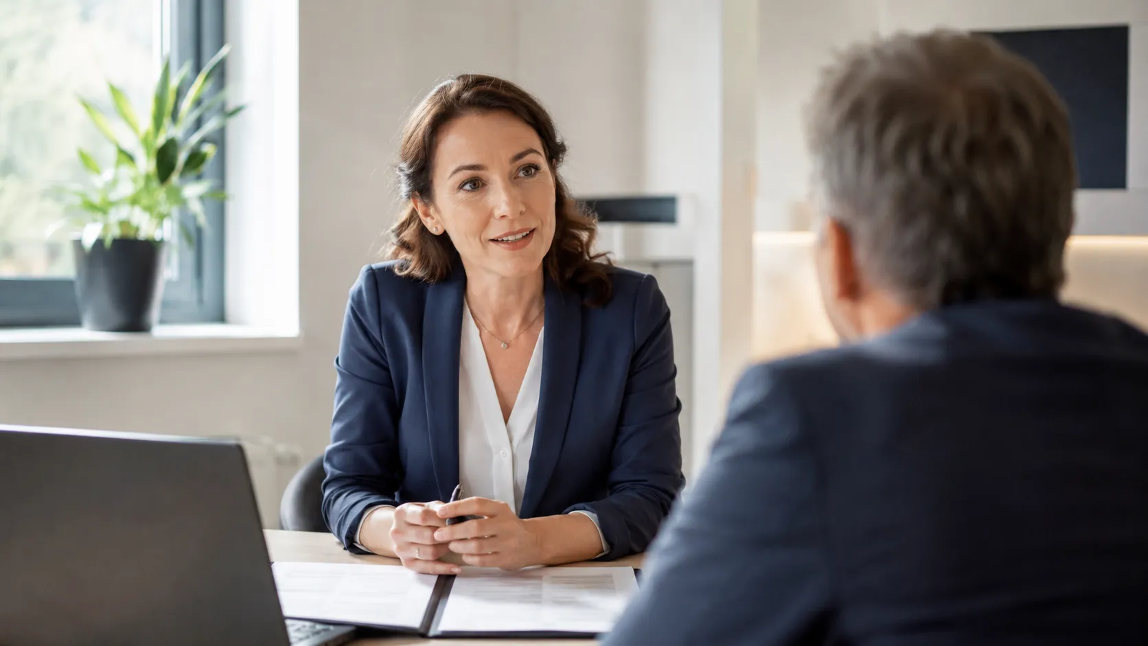 Finanzberaterin im Gespräch mit einem Kunden am Beratungstisch